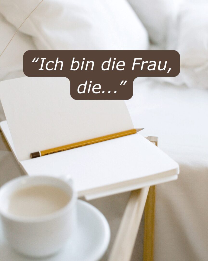 Offenes Notizbuch mit Bleistift auf einem Nachttisch, daneben eine Tasse Kaffee. Text: „Ich bin die Frau, die…“. Symbol für Reflexion und neues Selbstbild gegen Aufschieberitis.