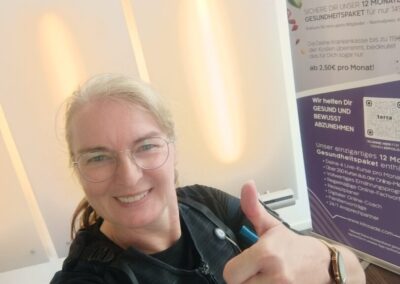 Andrea Oeing lächelt in die Kamera und zeigt den Daumen hoch während eines EMS-Trainings. Ein Moment voller Energie, Motivation und Lebensfreude.