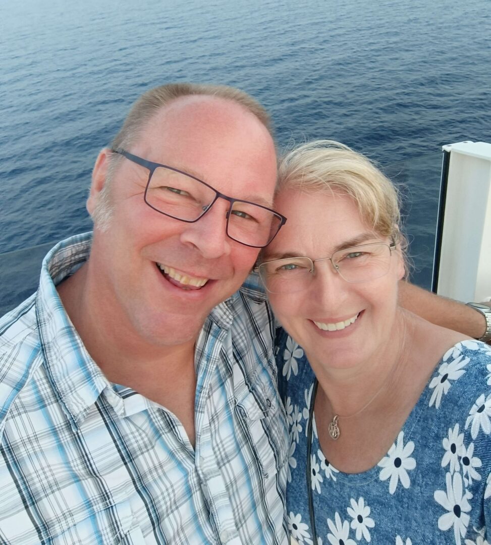 Andrea Oeing und ihr Mann René lächeln in die Kamera, im Hintergrund das Meer. Ein Moment voller Freude und gemeinsamer Auszeit.